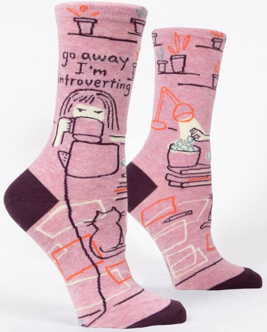 Go Away I’m Introverting funny novelty socks by Danna Bananas, featuring a woman sipping tea with a cat and cozy home design in pink and purple tones.