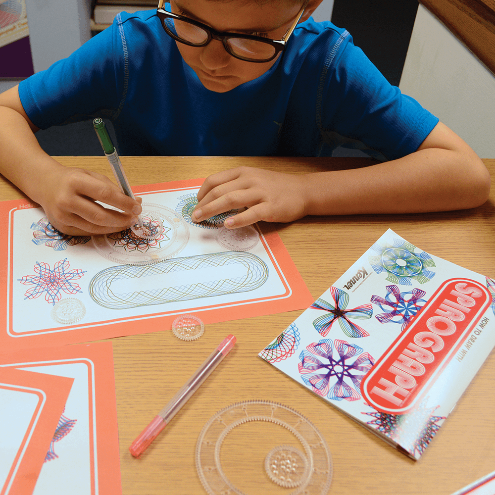 Little boy using the spirograph set.