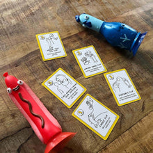 Chicken Vs Hot Dog Action Party Game pieces and cards on a wooden table, featuring flipping challenges for hilarious family fun.
