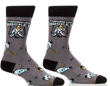 I Pucking Love Hockey funny socks by Danna Bananas featuring a cartoon goalie, hockey sticks, and pucks on a grey background—fun novelty gift for hockey fans.