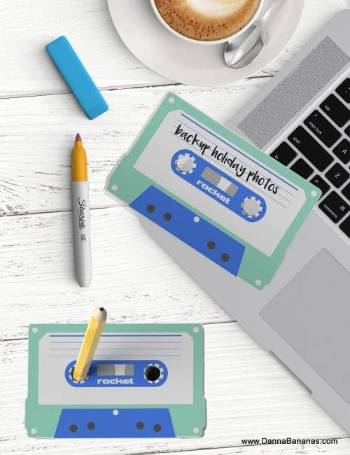 A laptop decorated with the charming Cas-Set Sticky Notes Set by Danna Bananas exudes a whimsical retro vibe, as one note declares "backup holiday photos." Alongside this setup, a cup of coffee sits companionably with a blue eraser and yellow marker pen, while a sharpened pencil is ready atop the sticky notes.