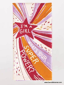 The "I'm A Girl What's Your Super Power" dish towel by Danna Bananas features vibrant swirls with a pink star and the phrase "What's your super power?" Made from super-absorbent cotton, it showcases colorful bursts in orange, purple, and pink.