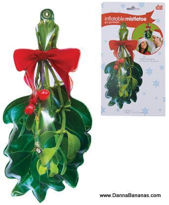 The Danna Bananas Inflatable Mistletoe is a charming Christmas decoration made of durable vinyl, adorned with green leaves, red berries, and a red bow. Displayed against a white background, the packaging to the right features an image of a couple about to kiss beneath this festive item.