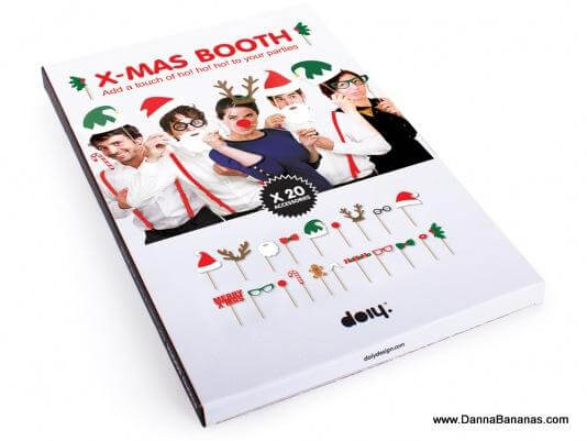 The "Photo Booth XMas" from Danna Bananas boasts a box featuring images of people using themed props ideal for a Christmas party, including glasses, hats, antlers, and more. This photo booth kit offers 20 pieces perfect for creating festive photo opportunities.