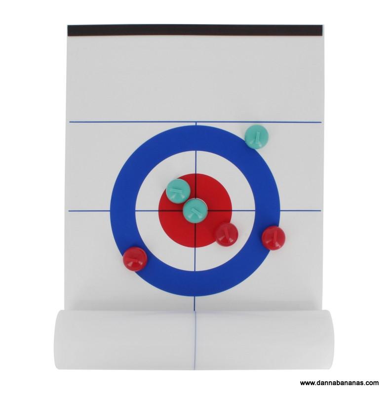 The Tabletop Curling Game by Danna Bananas features a magnetic curling sheet displaying three red stones and two green stones on the target, with a red stone nearest to the center. Ideal for tabletop play, this board is partially rolled at the bottom.