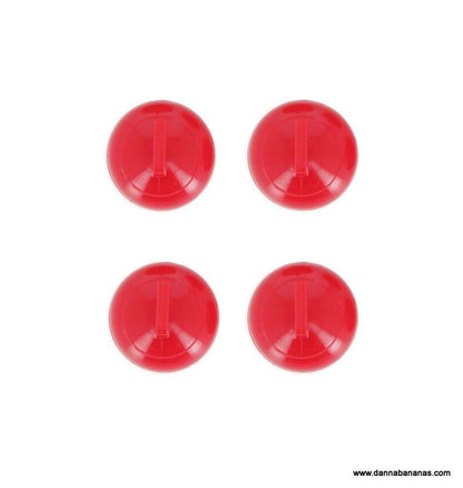 Four red plastic push buttons, set in a square pattern on a white background, evoke the strategic markers of the Danna Bananas Tabletop Curling Game.
