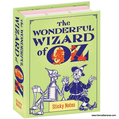 A book-shaped box, inspired by "The Wonderful Wizard of Oz" and showcasing illustrations of the Tin Man and Scarecrow, features a vibrant green cover with bold text. Upon opening, it reveals The Wonderful Wizard of Oz Sticky Notes by Danna Bananas, ideal for jotting down reminders during your own Yellow Brick Road adventures.